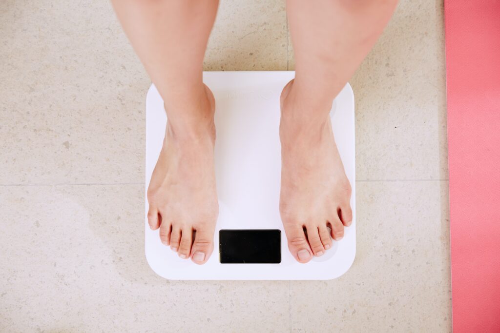 scales measure progress woman standing on bathroom scales